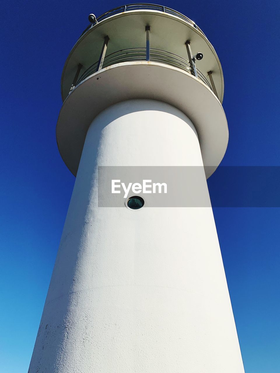 LOW ANGLE VIEW OF LIGHTHOUSE BY BUILDING AGAINST CLEAR SKY