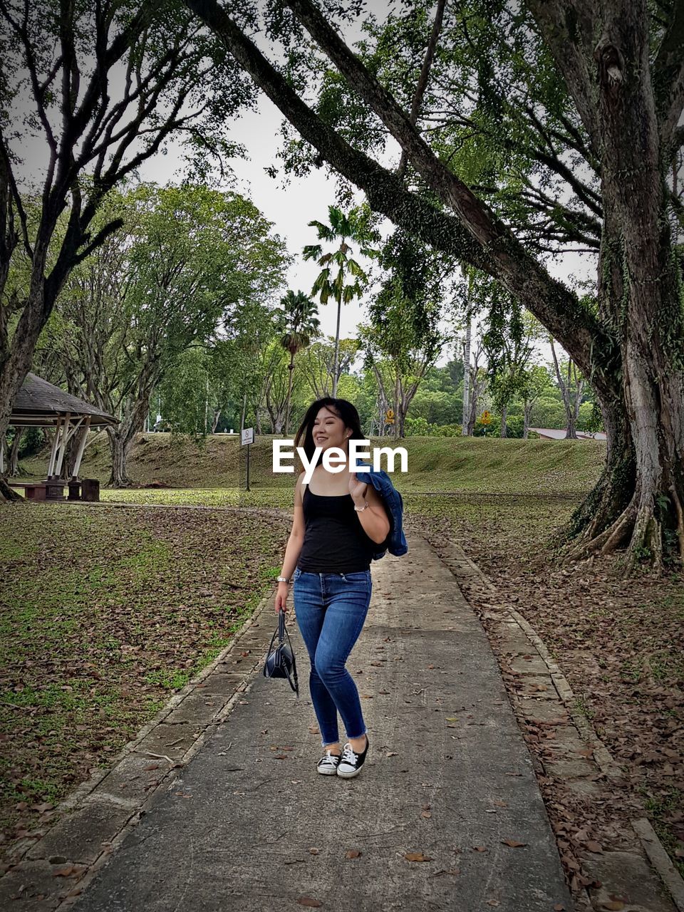 FULL LENGTH OF WOMAN ON FOOTPATH BY TREES