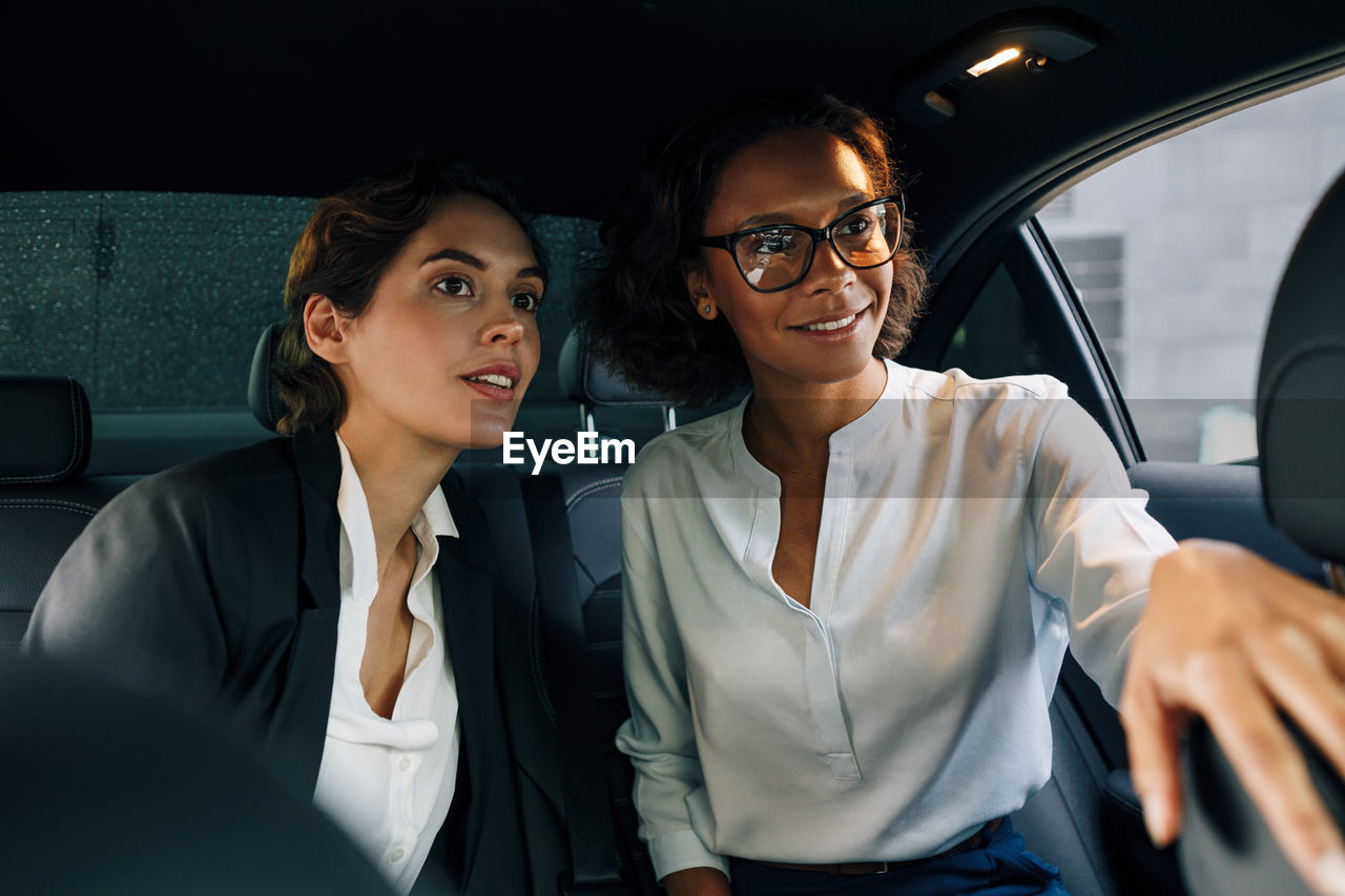 Beautiful young woman sitting in car