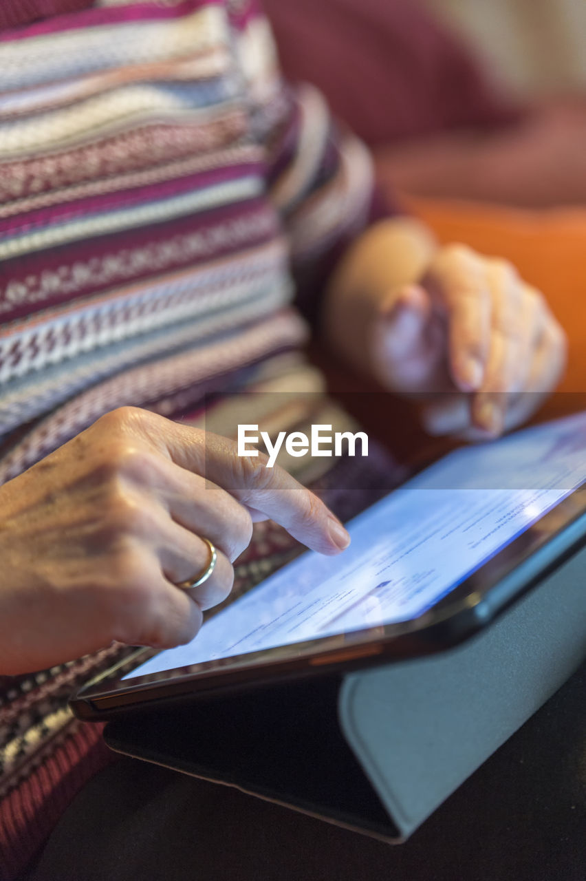 Senior woman using tablet at home, close-up