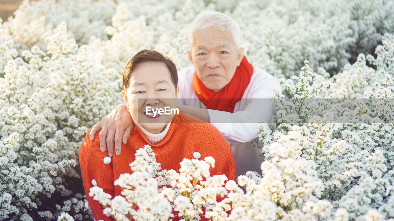 Asian senior elderly couple celebrating christmas holiday season and red sweater positive happiness