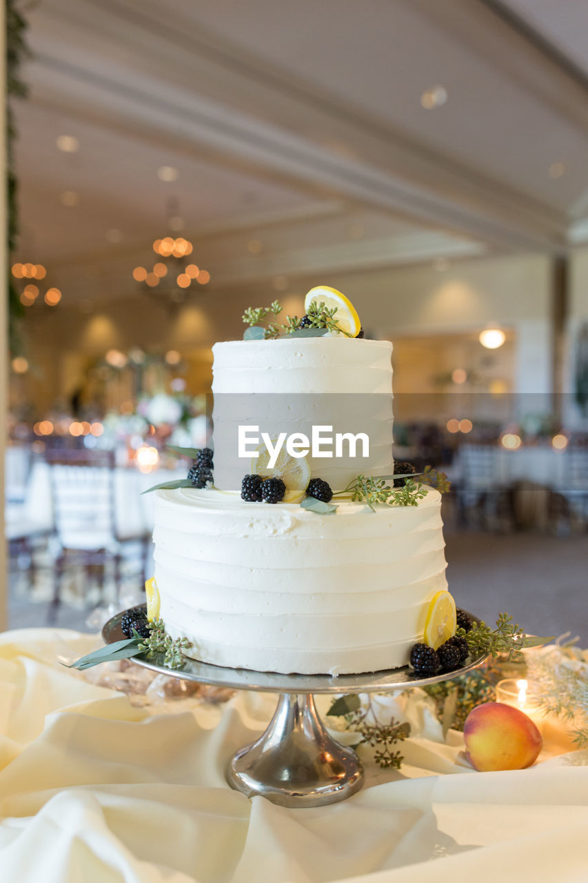 Close-up of wedding cake on stand at table