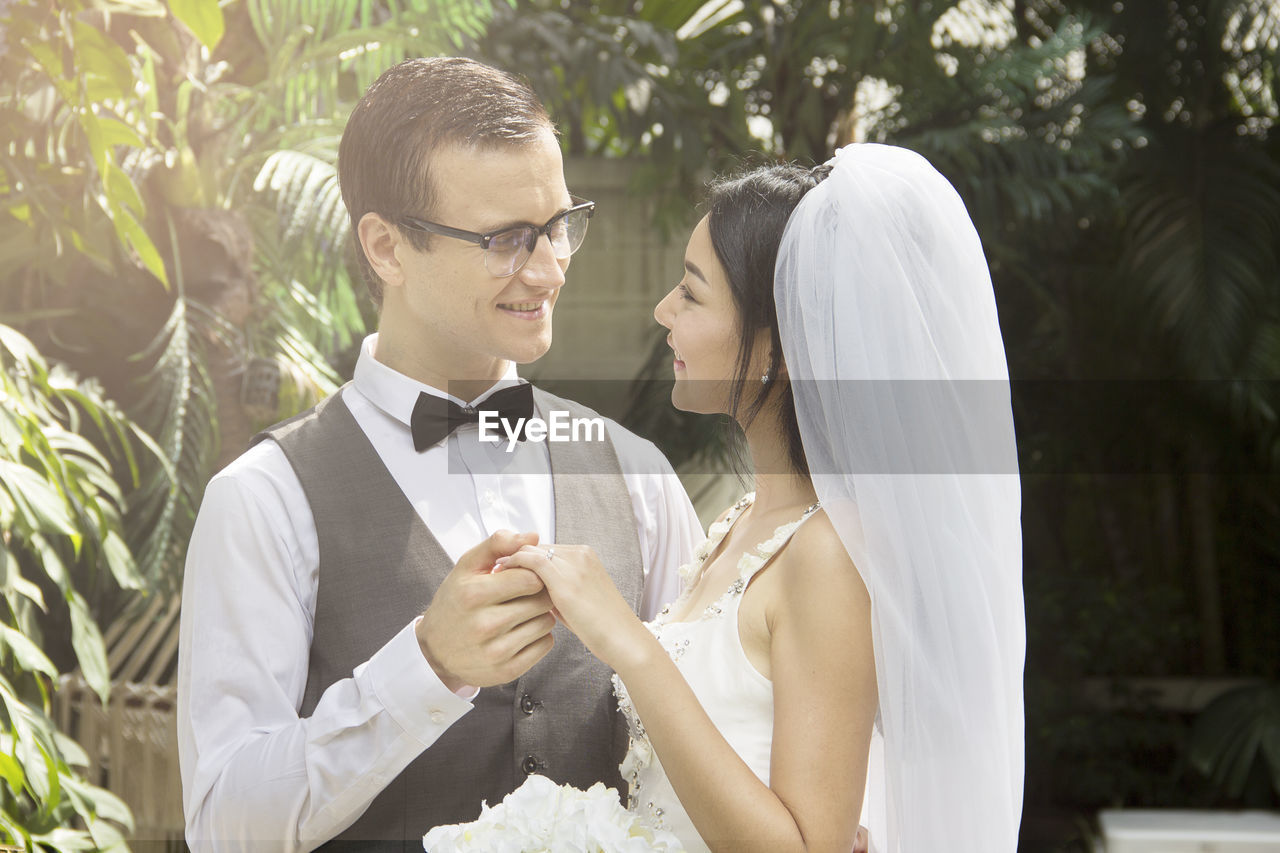 Smiling groom holding hand of beautiful bride