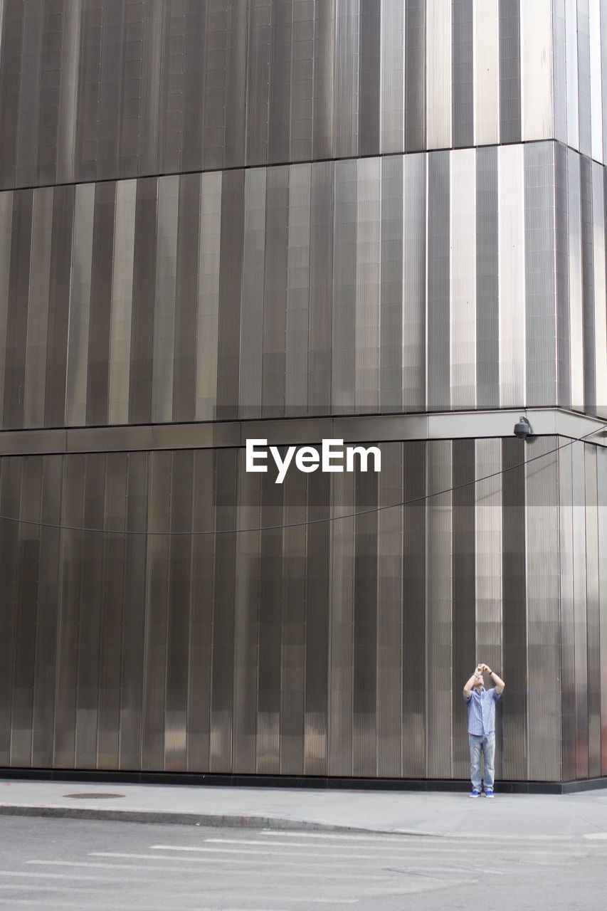 FULL LENGTH REAR VIEW OF MAN WALKING IN BUILDING