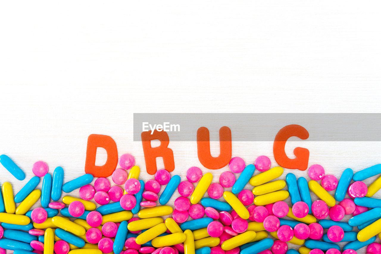 Close-up of multi colored pills and text on table