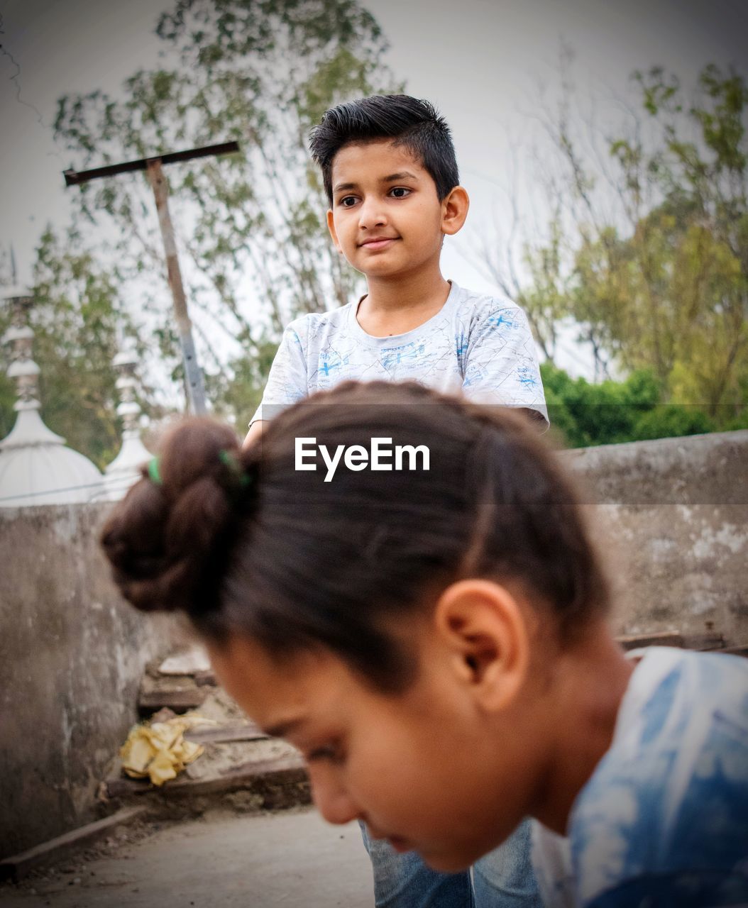 PORTRAIT OF CUTE BOY AND WOMAN WITH DAUGHTER IN BACKGROUND