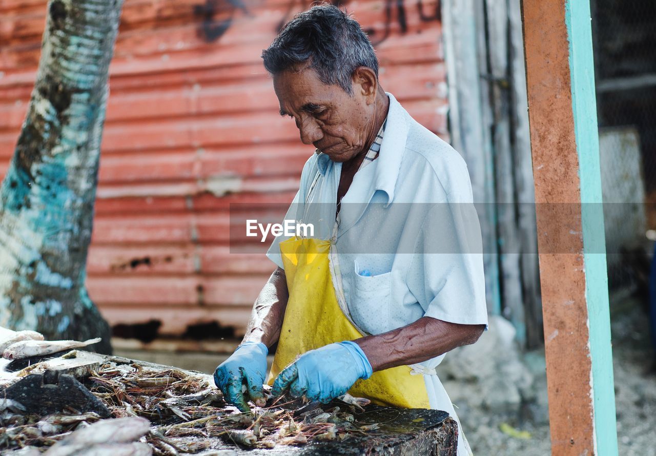 Man cleaning fishes at market