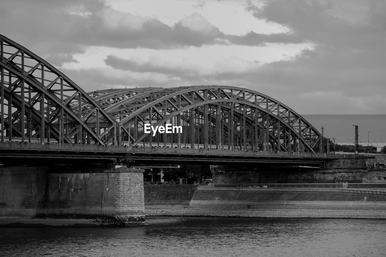 Arch bridge over river against sky