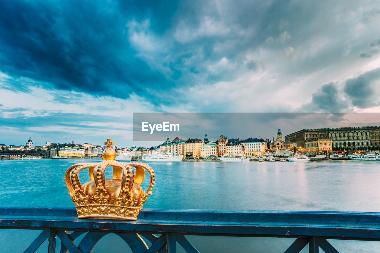 Crown on railing against sea in city