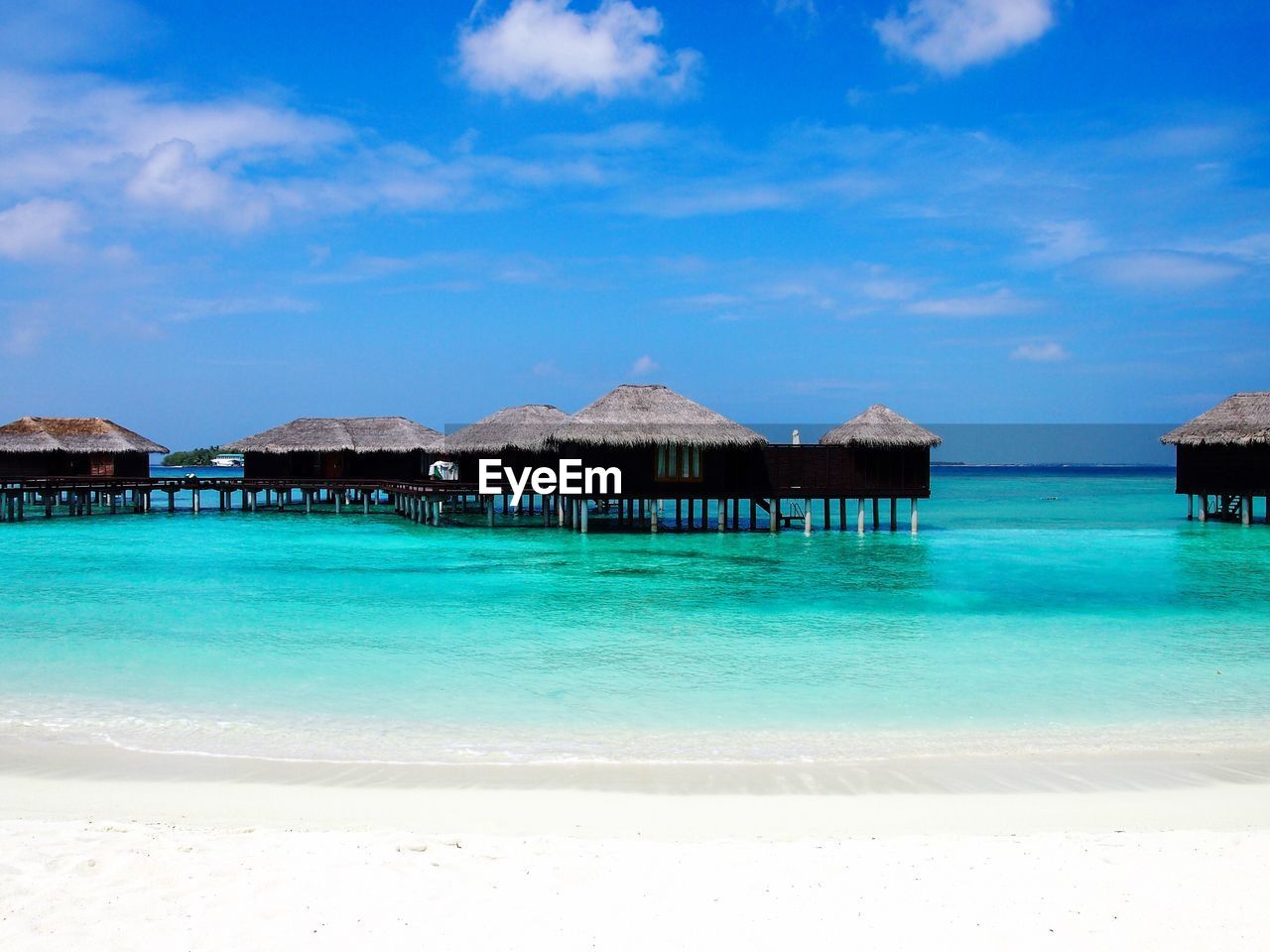 Built structure on beach against blue sky