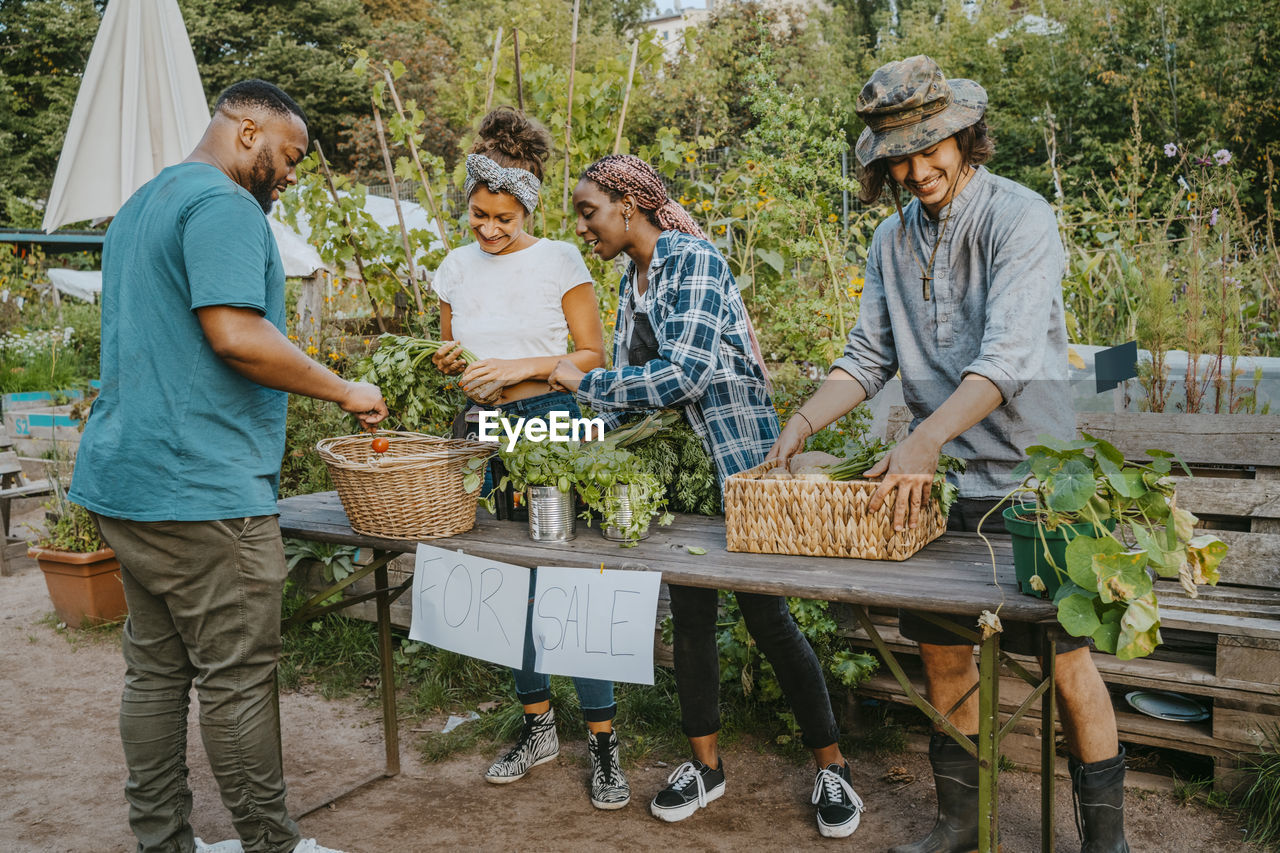 Male and female farmers selling vegetables in market