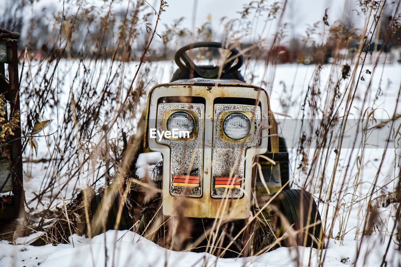 Abandoned tractor on snow covered field