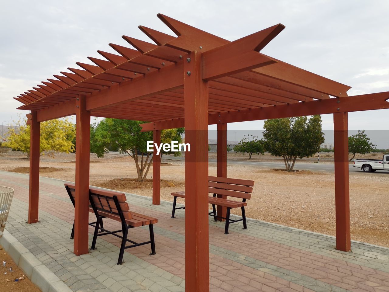 Empty chairs and table at beach against sky