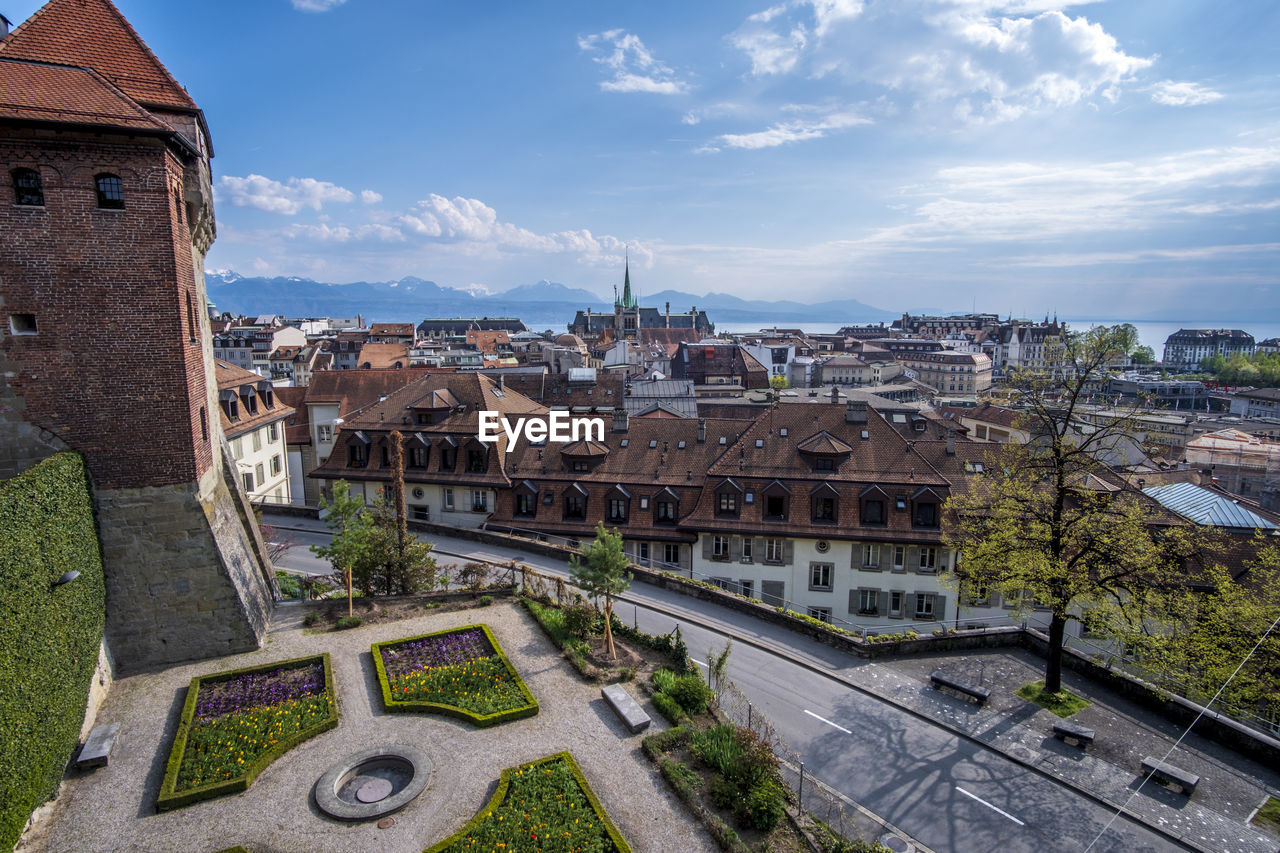 HIGH ANGLE VIEW OF BUILDINGS IN TOWN AGAINST SKY