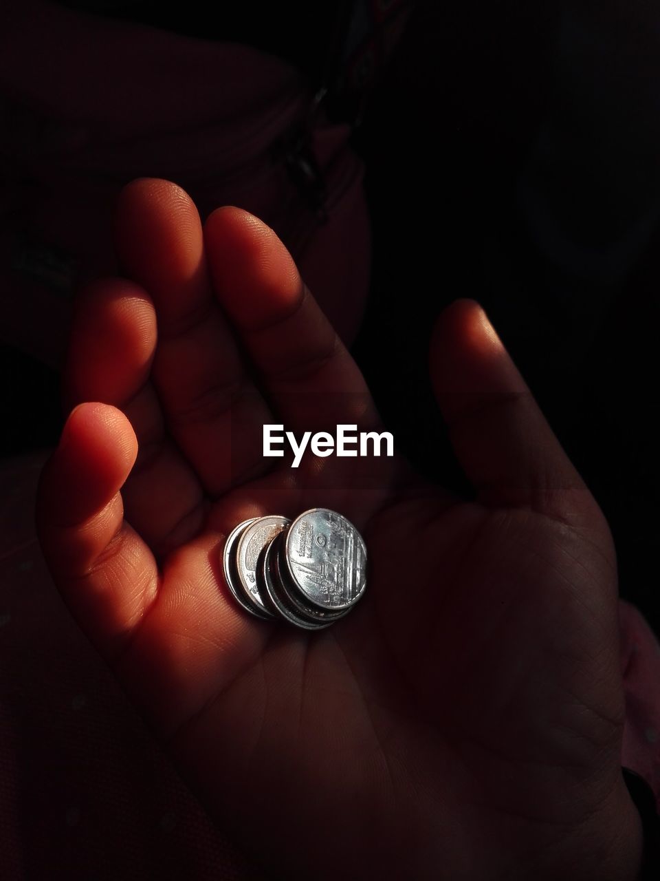 hand, close-up, finger, one person, darkness, holding, indoors, light, finance, ring, jewellery, coin, wealth, jewelry