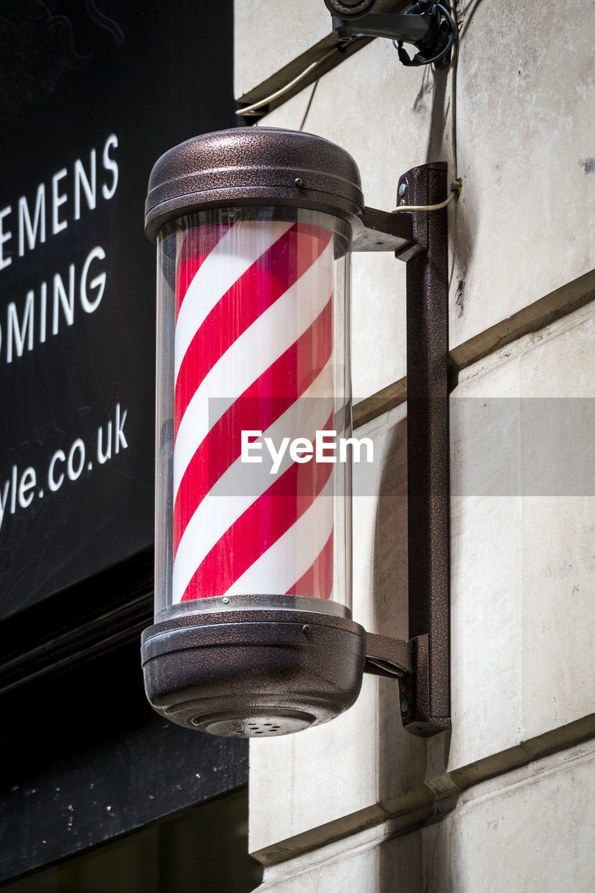Low angle view of barbers pole on wall