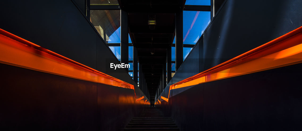 LOW ANGLE VIEW OF ILLUMINATED BRIDGE AGAINST ORANGE SKY