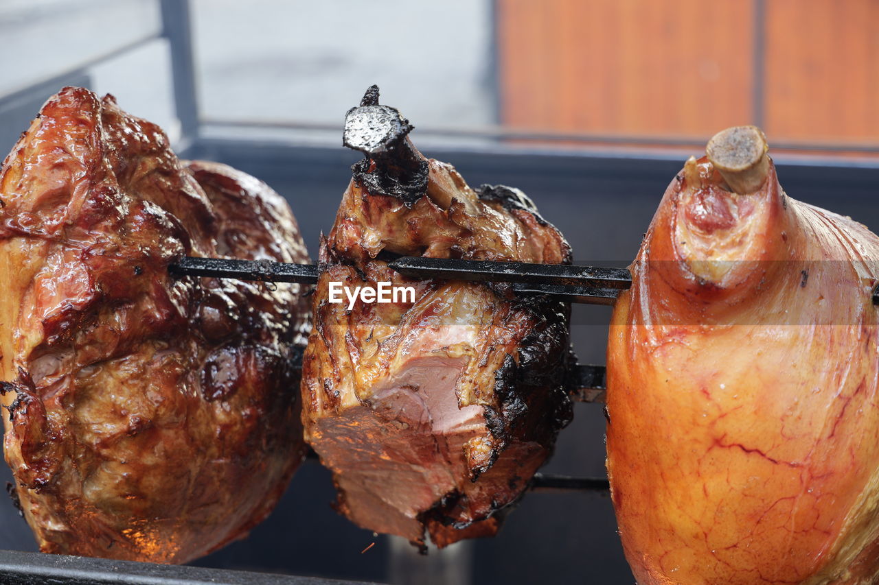 CLOSE-UP OF ROASTED MEAT ON BARBECUE