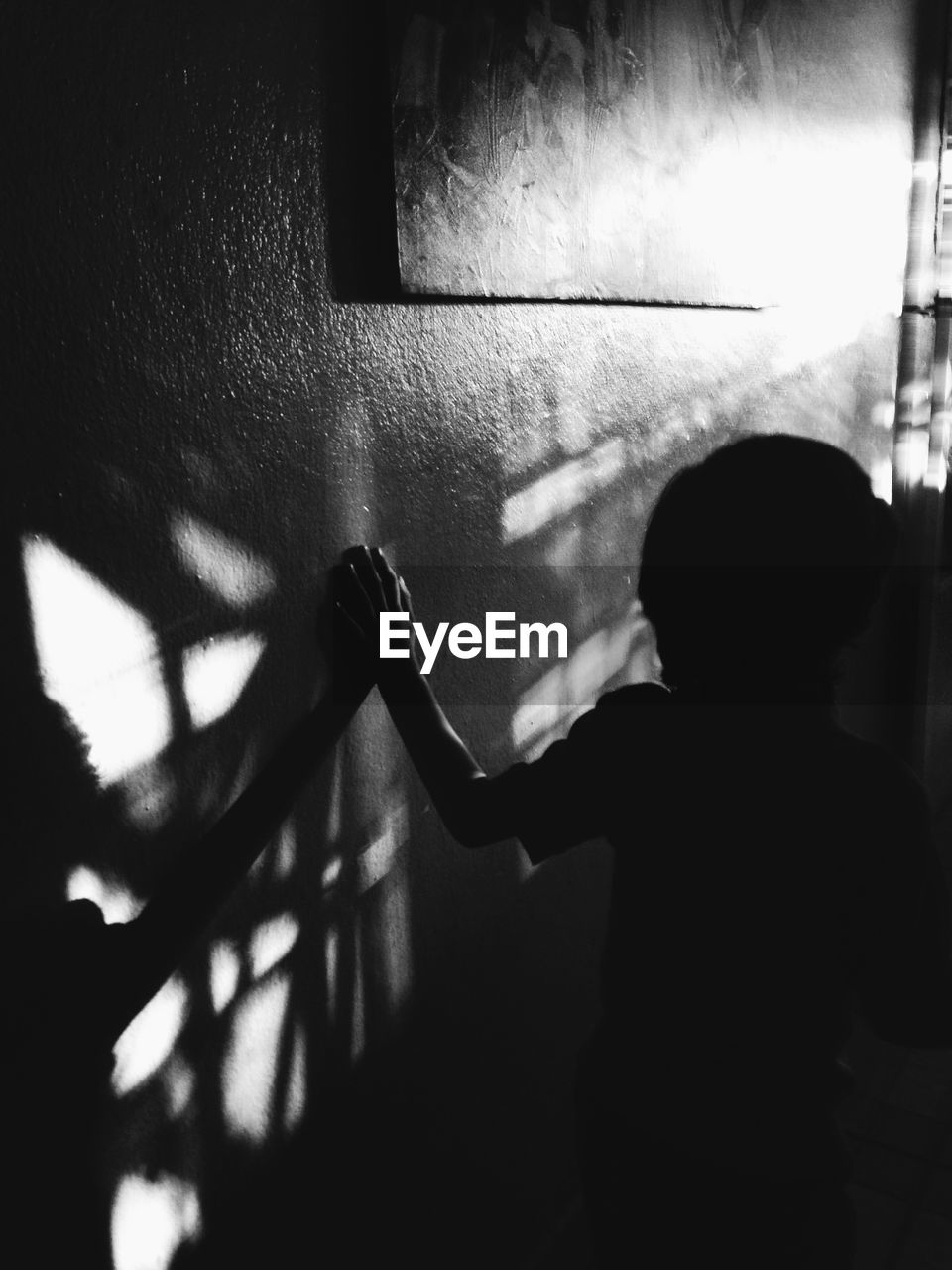 Silhouette boy by the wall