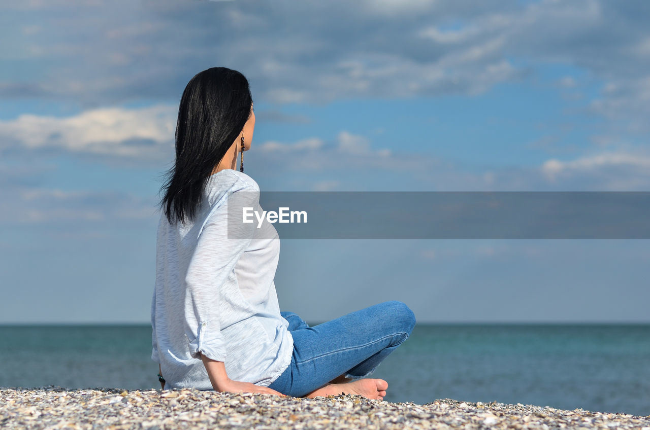 Full length of woman looking at sea against sky