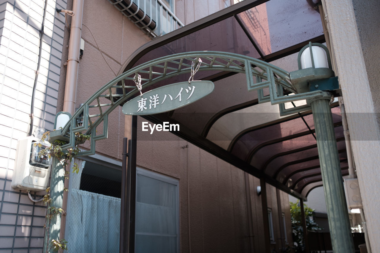 LOW ANGLE VIEW OF TEXT ON BUILDING IN CITY