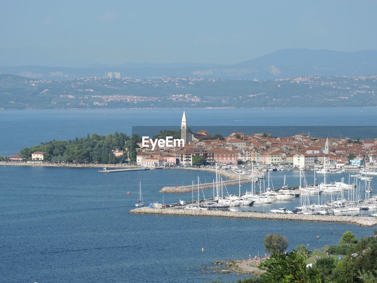 High angle view of city by sea against sky