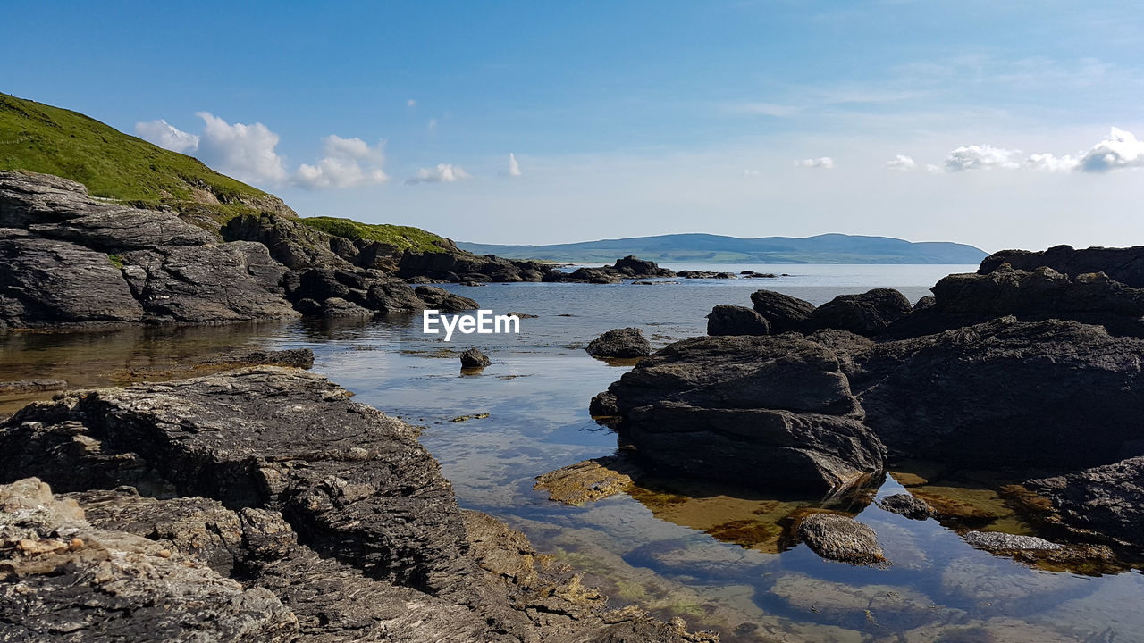 Rocks on beach against sky