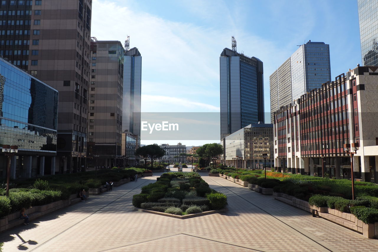 Footpath against skyscrapers in city