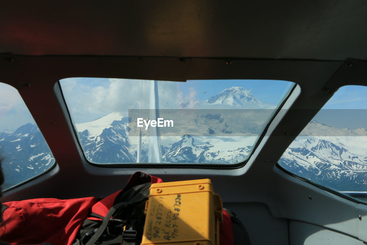 VIEW OF LANDSCAPE SEEN THROUGH AIRPLANE WINDOW DURING WINTER