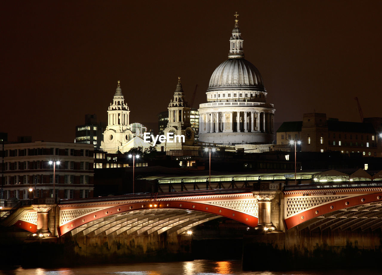 ILLUMINATED CATHEDRAL IN CITY AGAINST SKY