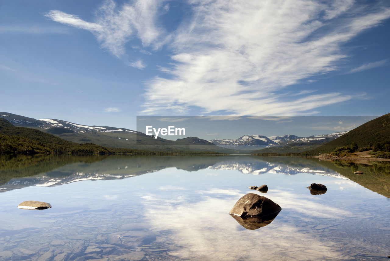 ROCKS IN LAKE AGAINST SKY