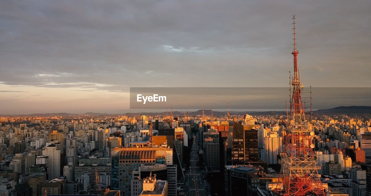 Aerial view of buildings against cloudy sky