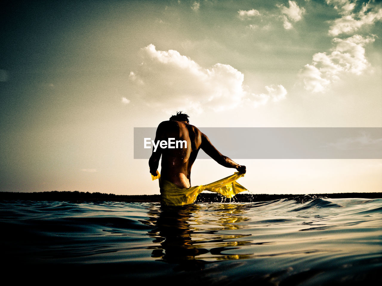 MAN IN SEA AGAINST SKY