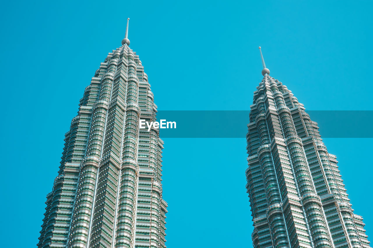 Low angle view of petronas towers against clear blue sky