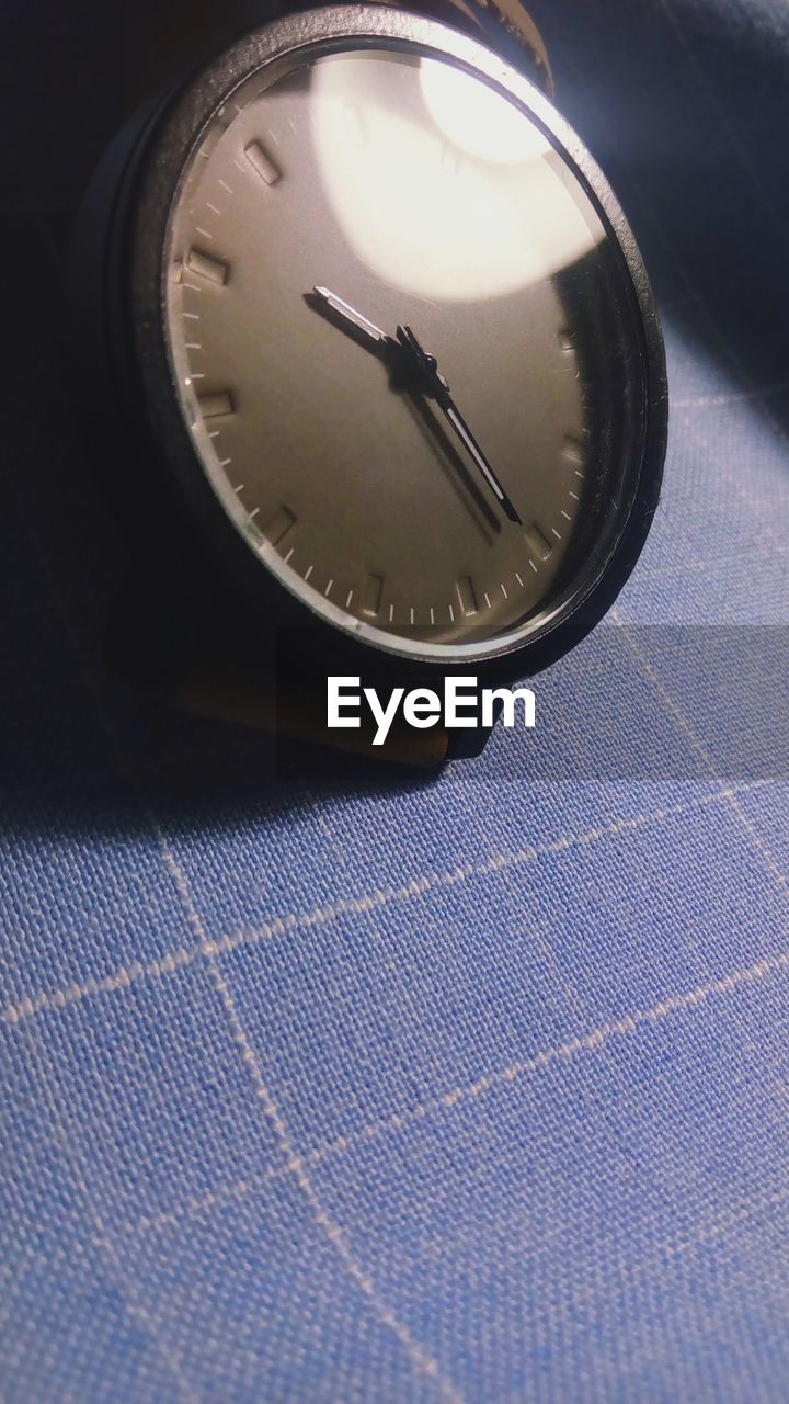 Close-up of wristwatch on tablecloth