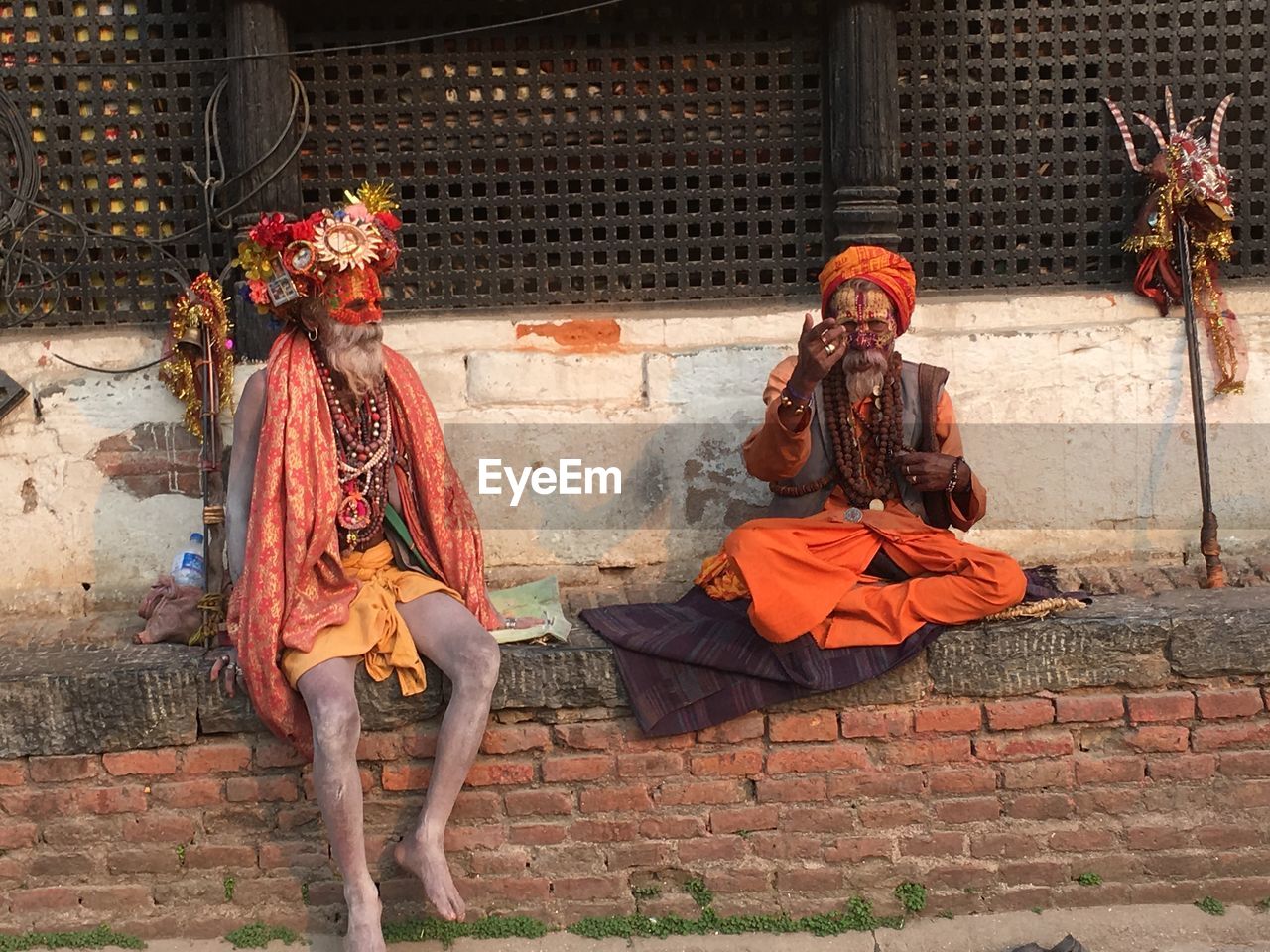 Sadhus sitting against building