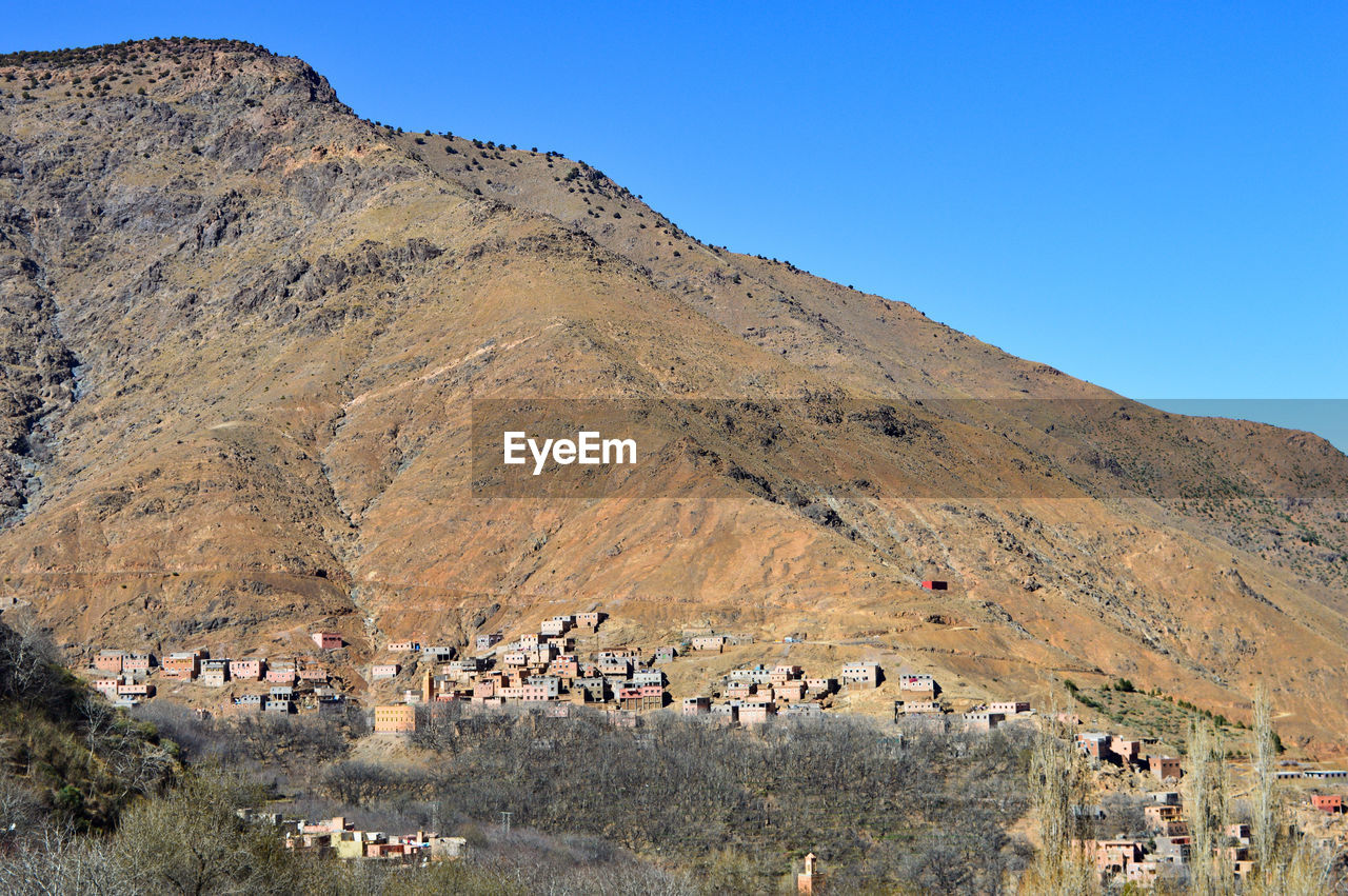 HIGH ANGLE VIEW OF BUILDINGS ON MOUNTAIN AGAINST CLEAR SKY