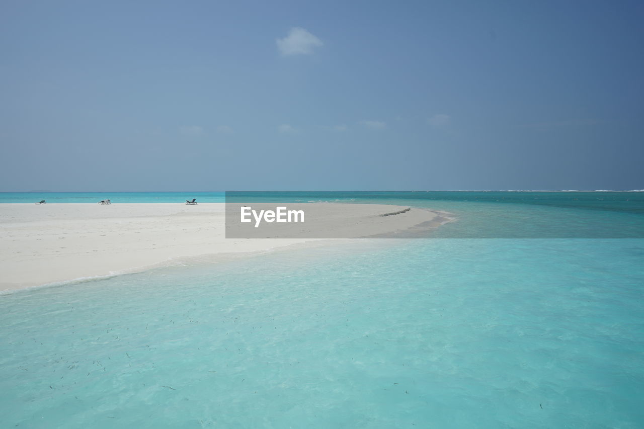 Scenic view of beach against blue sky