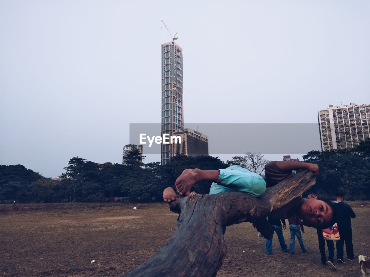 MEN STANDING BY MODERN BUILDINGS AGAINST CLEAR SKY IN CITY