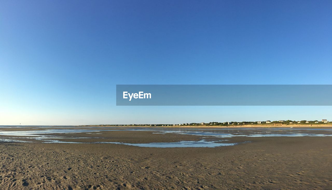 Scenic view of beach against blue sky