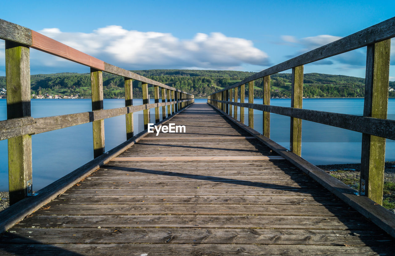 Footbridge over wooden bridge against sky