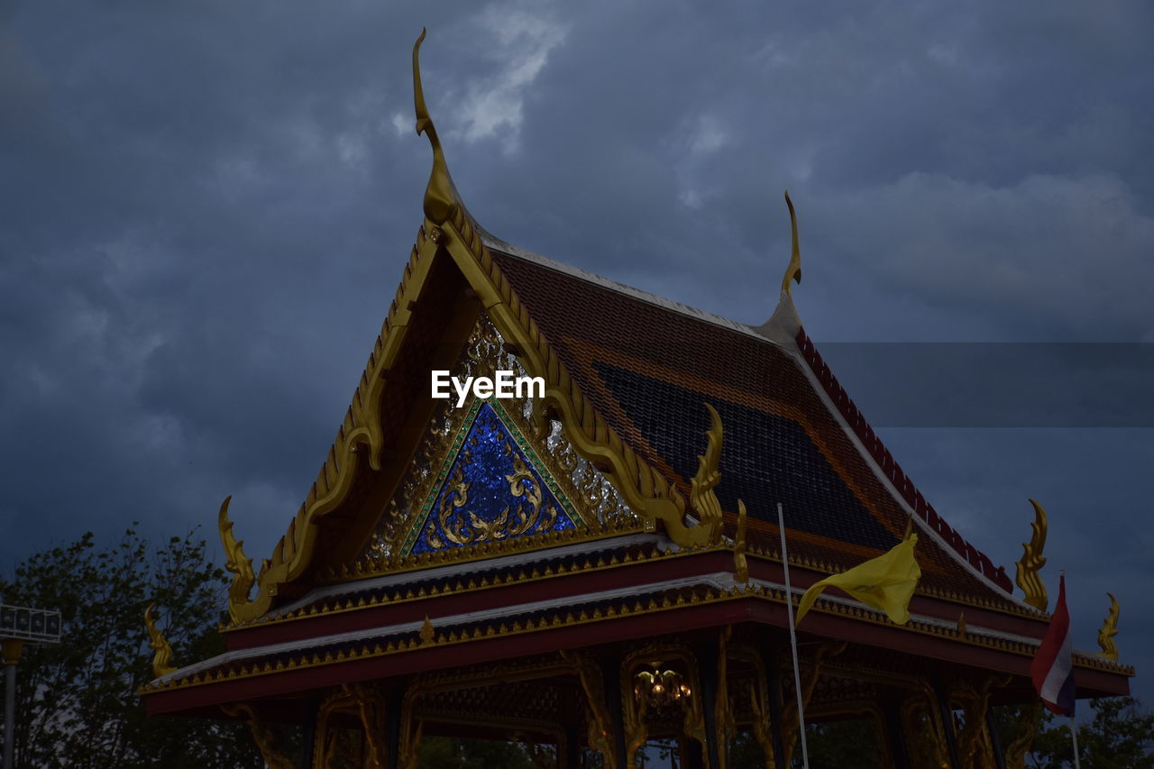 LOW ANGLE VIEW OF TEMPLE BUILDING AGAINST SKY AT DUSK