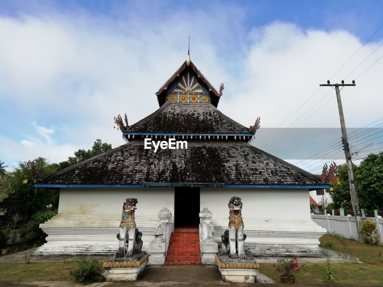 PEOPLE OUTSIDE TEMPLE AGAINST BUILDING