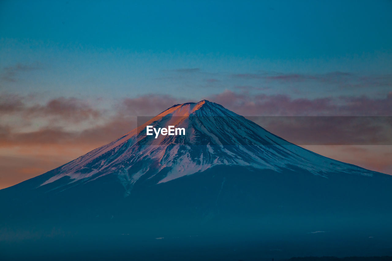 Scenic view of snowcapped mount fuji against sky during sunrise