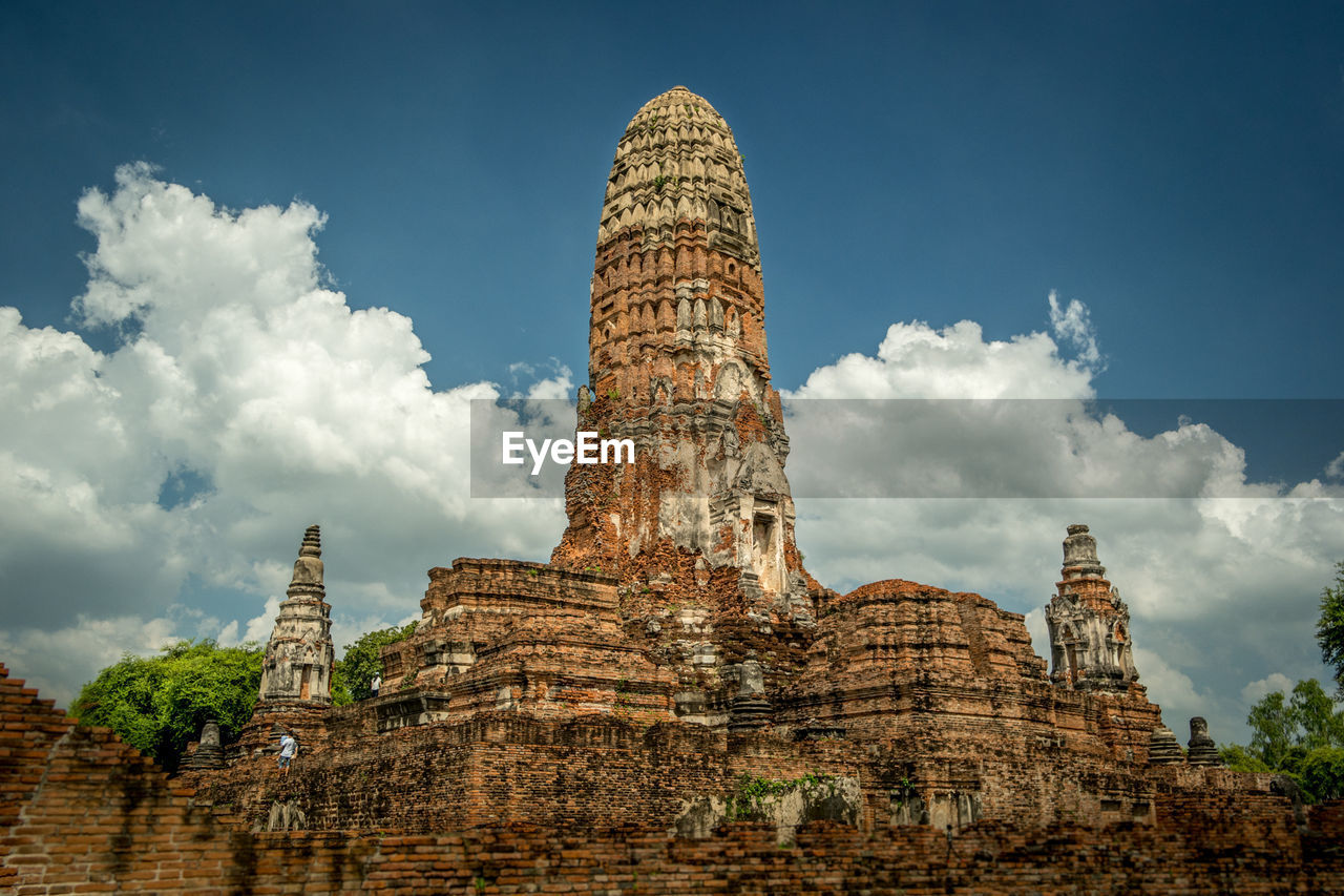 Low angle view of temple against cloudy sky at ayuthaya