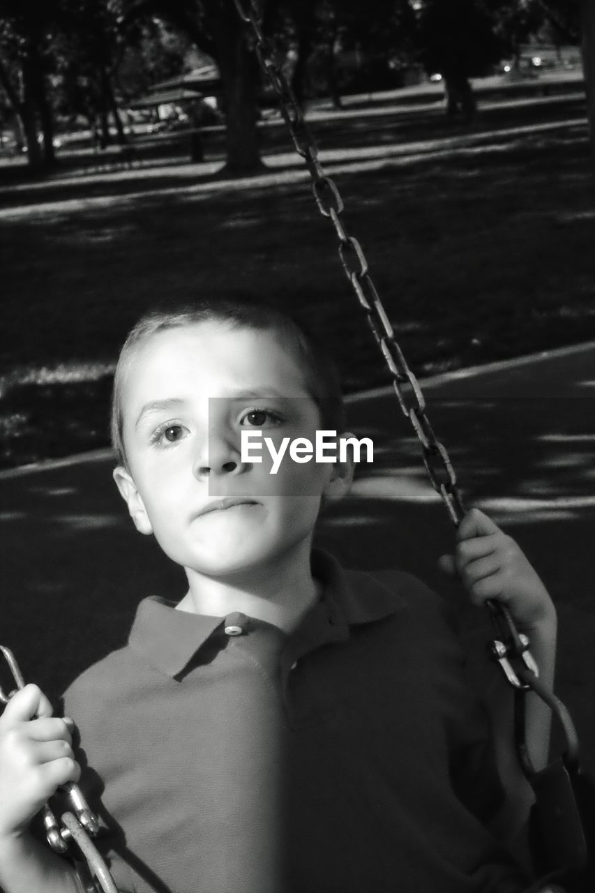 Boy swinging in park