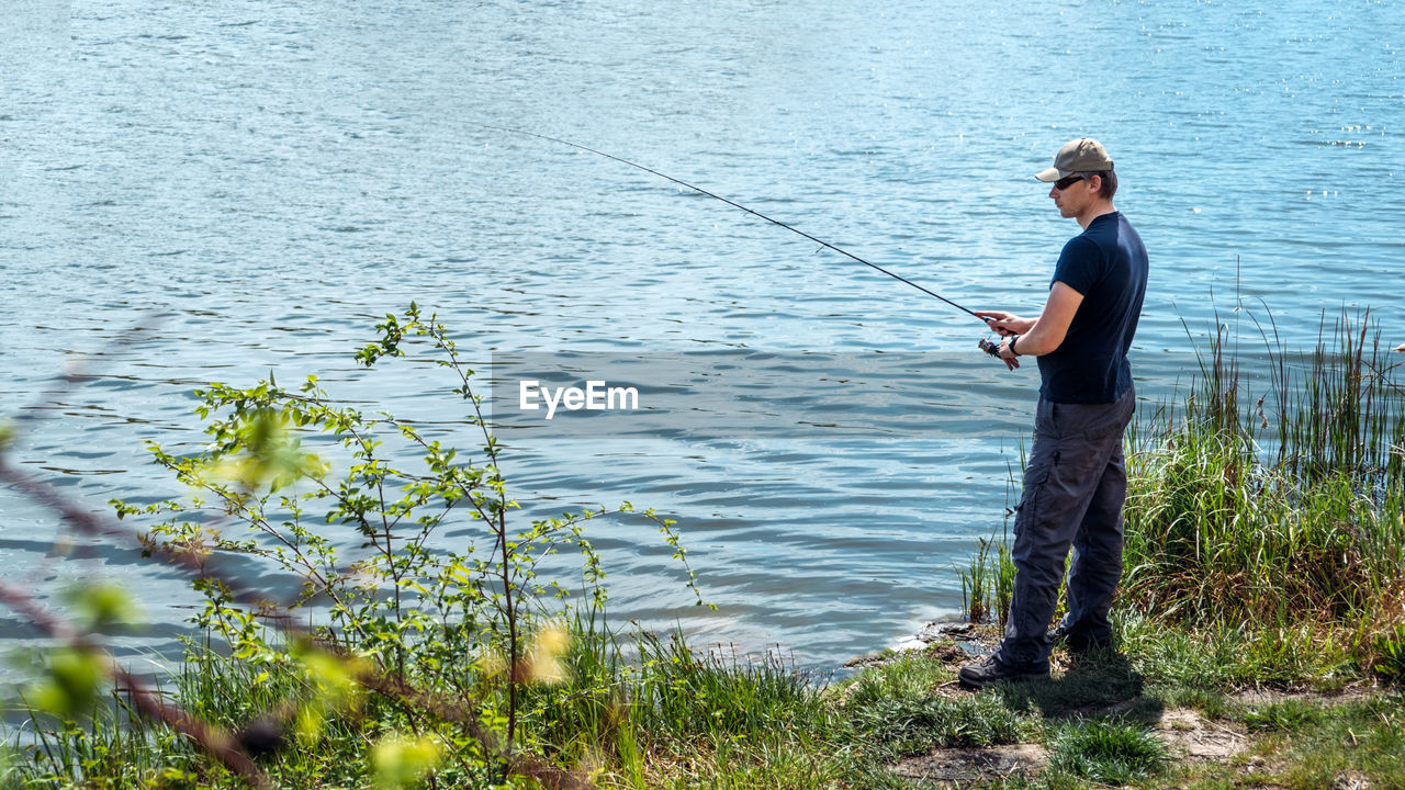 Fisherman with spinning rod on nature background. angler man with fishing spinning 