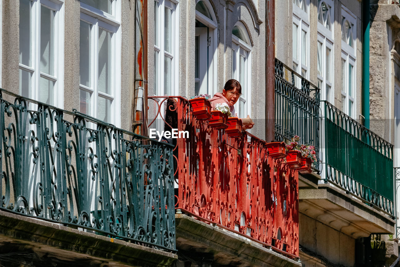 FULL LENGTH OF MAN ON RED BUILDING