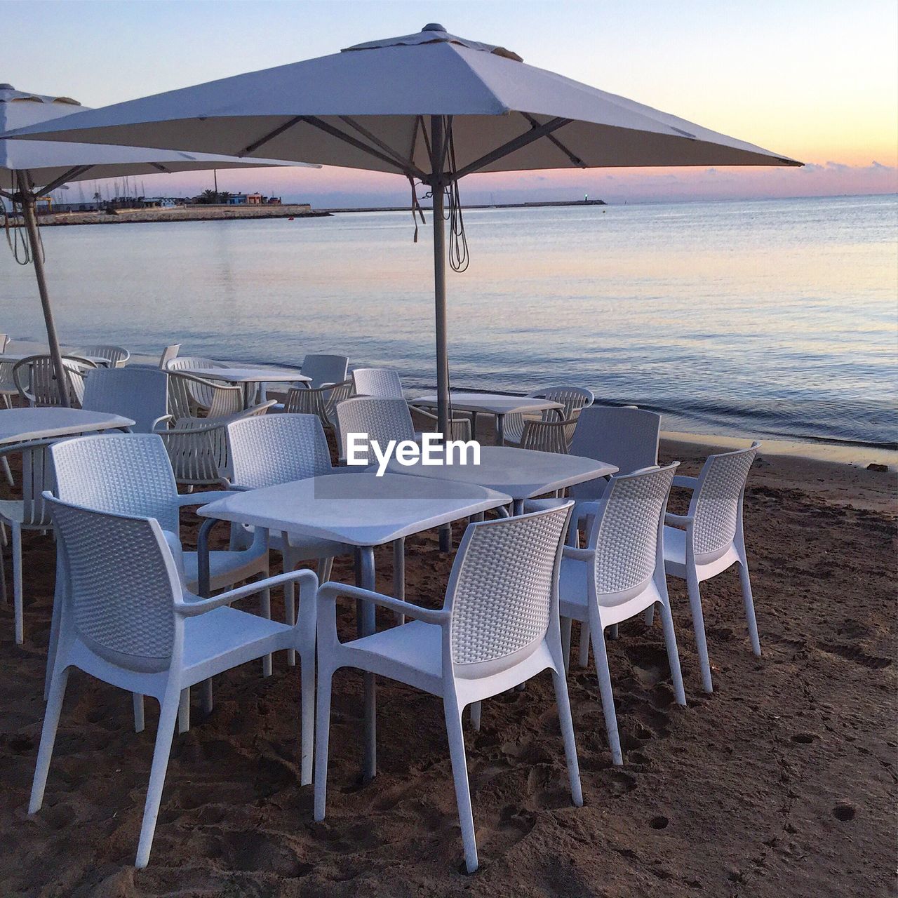 DECK CHAIRS AND TABLE BY SEA AGAINST SKY