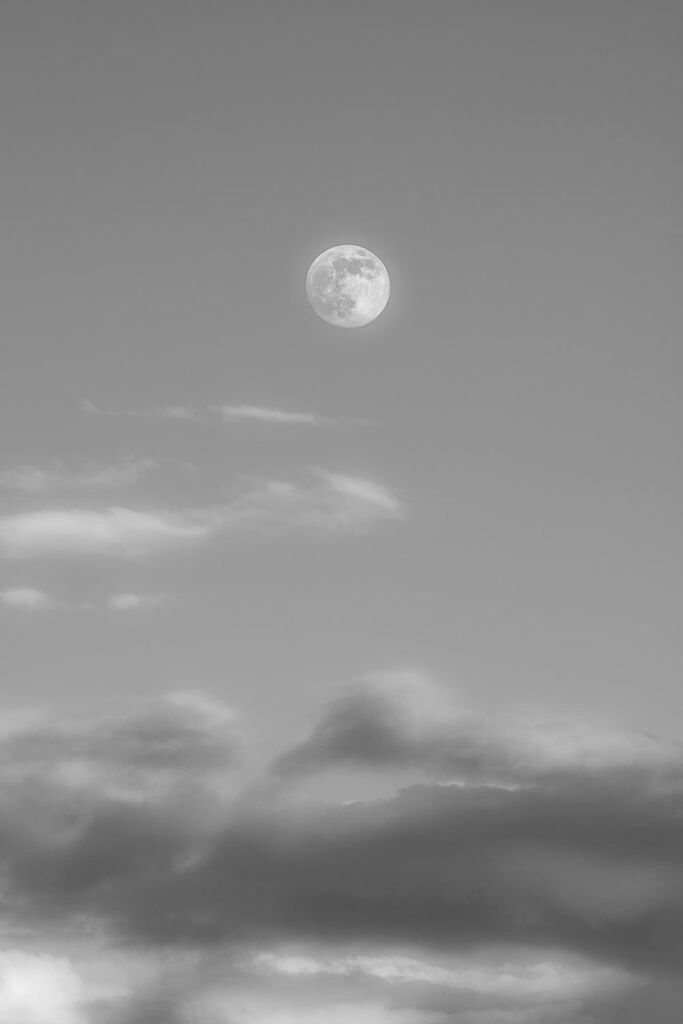 Low angle view of moon in cloudy sky